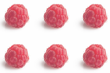 Six big lighted raspberries arranged in a symmetric pattern on white background 