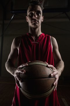 Portrait of basketball player unsmiling and holding a basketball