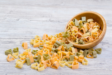 Various combinations of pasta on wooden background, burlap bags, bamboo bowls. diet and nutritional concept.