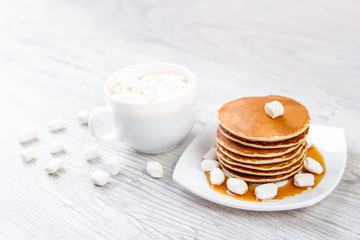 Delicious pancakes on a white background, wooden background, maple syrup, Cup of coffee