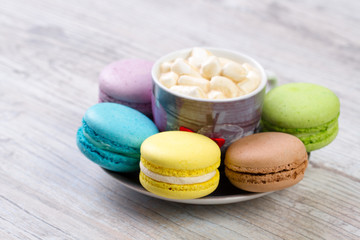 collection of colorful French macarons are next to each other around the plates