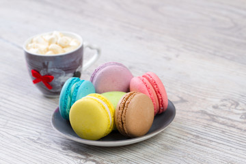 collection of colorful French macarons are next to each other around the plates