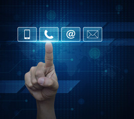 Hand pressing telephone, mobile phone, at and email buttons over