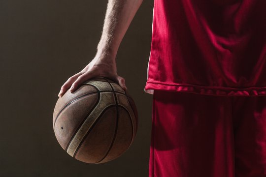 Close up on a basketball held by basketball player