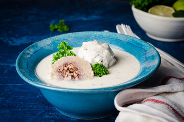 Kibbeh bil laban - arabian yogurt soup with stuffed bulgur cutletson dark background. Selective focus