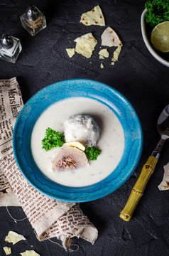Kibbeh bil laban - arabian yogurt soup with stuffed bulgur cutletson dark background. Selective focus