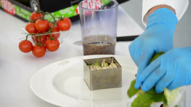 Hands of chef adding ingredients cooking like mustard, oil, honey, salt and pistachio, to a bowl to beat