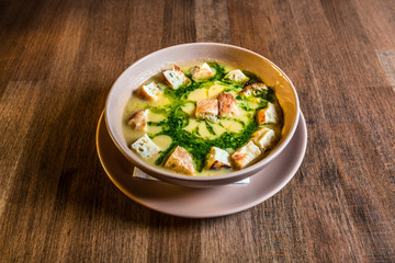 Creamy pea soup with croutons on a wooden table. Selective focus
