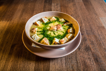 Creamy pea soup with croutons on a wooden table. Selective focus