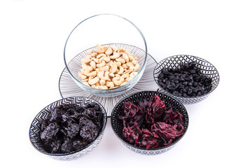 Bowls with dried blueberries, plums, hibiscus and cashews