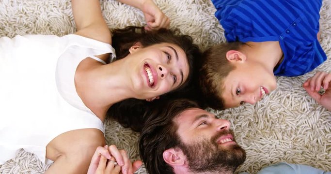 Happy family smiling and lying on a carpet