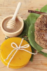 Honey with honeycomb and wax on green leaves.