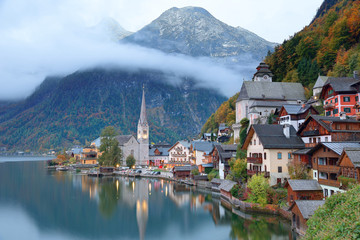 Fototapeta na wymiar Early morning view of Hallstatt, a charming lakeside village in Salzkammergut region of Austria, with reflections on smooth lake water in colorful autumn season ~ A beautiful UNESCO heritage site