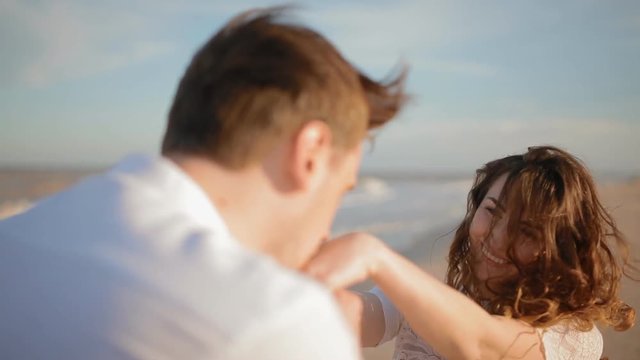 Man kiss woman's hands on  the beach
