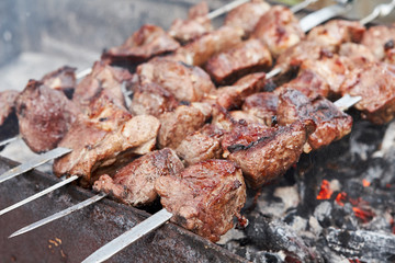 Lamb Shish kebab on Fire. Appetizing fresh meat shish kebab prepared on a grill wood coal, outdoor.