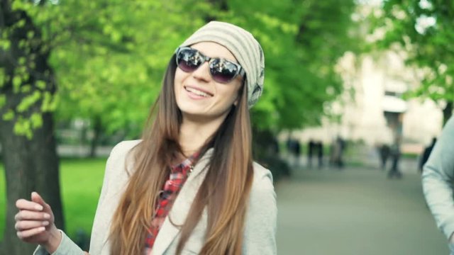 Portrait of happy, hipster woman walking in city park
