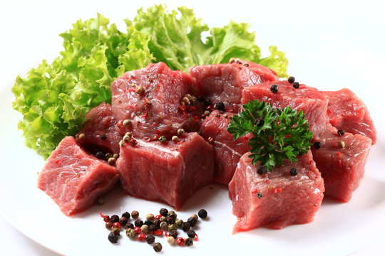 Raw Beef with green salad close up  isolated on white background