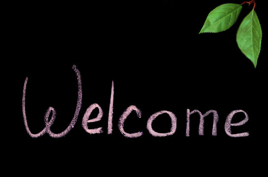 the word "Welcome" in chalk on black background