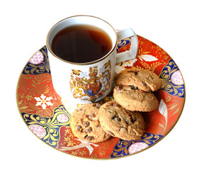 A stack of chocolate chip cookies in vintage red plate and cup of tea, isolated on a white background