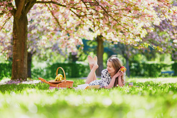 Girl having picnic in cherry garden