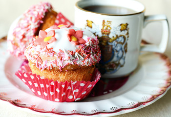 Vintage cup with tea and cupcake decorated with flower