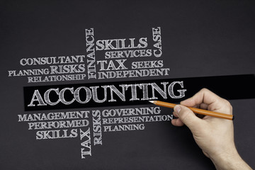 Hand with a white pencil writing: ACCOUNTING word cloud