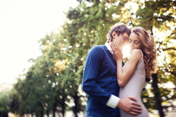 Naklejka premium Young couple in love, outdoors portrait at the sunset. Romantic time in the sunset garden