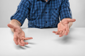 Cropped portrait of a man sits gesticulating.