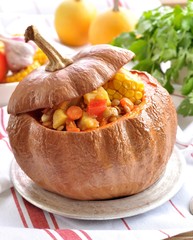 Vegetable stew of potatoes, corn, sweet pepper, onion, tomato with lentils, baked in a pumpkin.