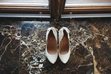 White shoe of the Bride on the marble floor. vintage wedding theme background