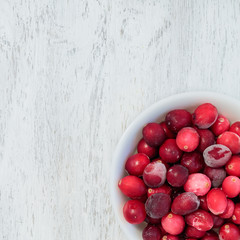 Red berries on a white rustic wood background