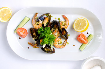 dish of seafood with vegetables and lemon