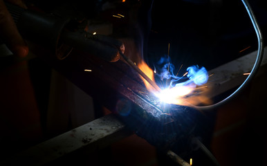 welding a piece of iron and sparks