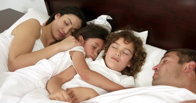  Family sleeping together on bed