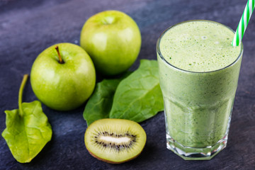 green smoothie with spinach, kiw iand apple  on a dark background, selective focus