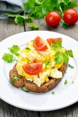 Scrambled eggs and tomato slices on bread