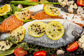 Fresh sea bream and salmon on dark  background