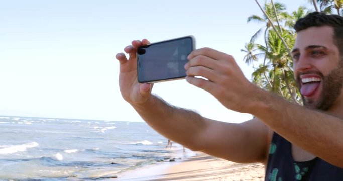 Guy taking a selfie in a tropical beach