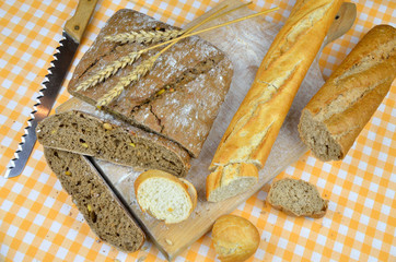 Sliced dark rustic bread and white baguette