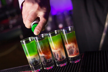 colored alcoholic cocktail is pours