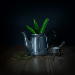 Green chili peppers in a metal teapot