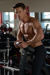 muscular bodybuilder preparing to exercise in the gym.