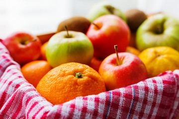Box full of fresh fruits. Fruit harvest - apples, oranges, lemon, kiwi, banana. Rustic background.