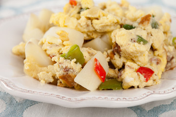 Macro shot of scrambled eggs with Anaheim chilies, boiled potatoes, green peppers, and onions