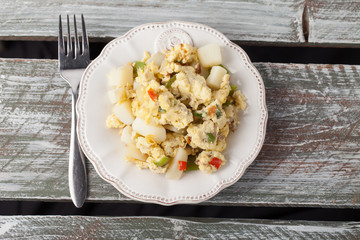 Scrambled eggs with Anaheim chilies, boiled potatoes, green peppers, and onions top view on a...