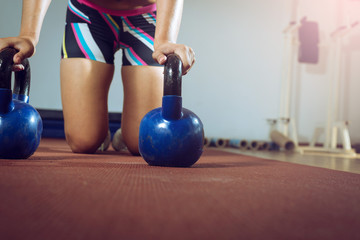 Fitness woman doing push ups with kettlebells
