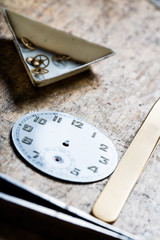 antique watch quadrant and clockworks on a repair table