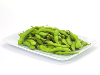 Edamame soy beans in a white ceramic dish.