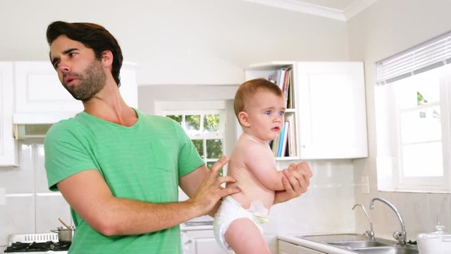  Father checking diaper of son