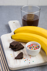 Ingredients for Banana Pops on a white cutting board